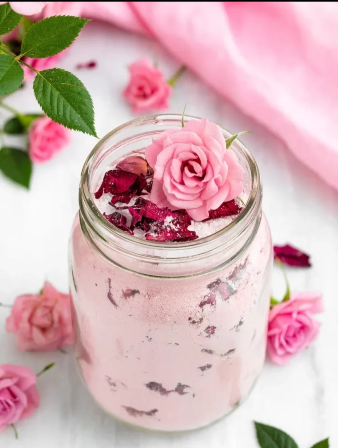 A flower-strewn ritual milk bath with pink salt and rose quartz